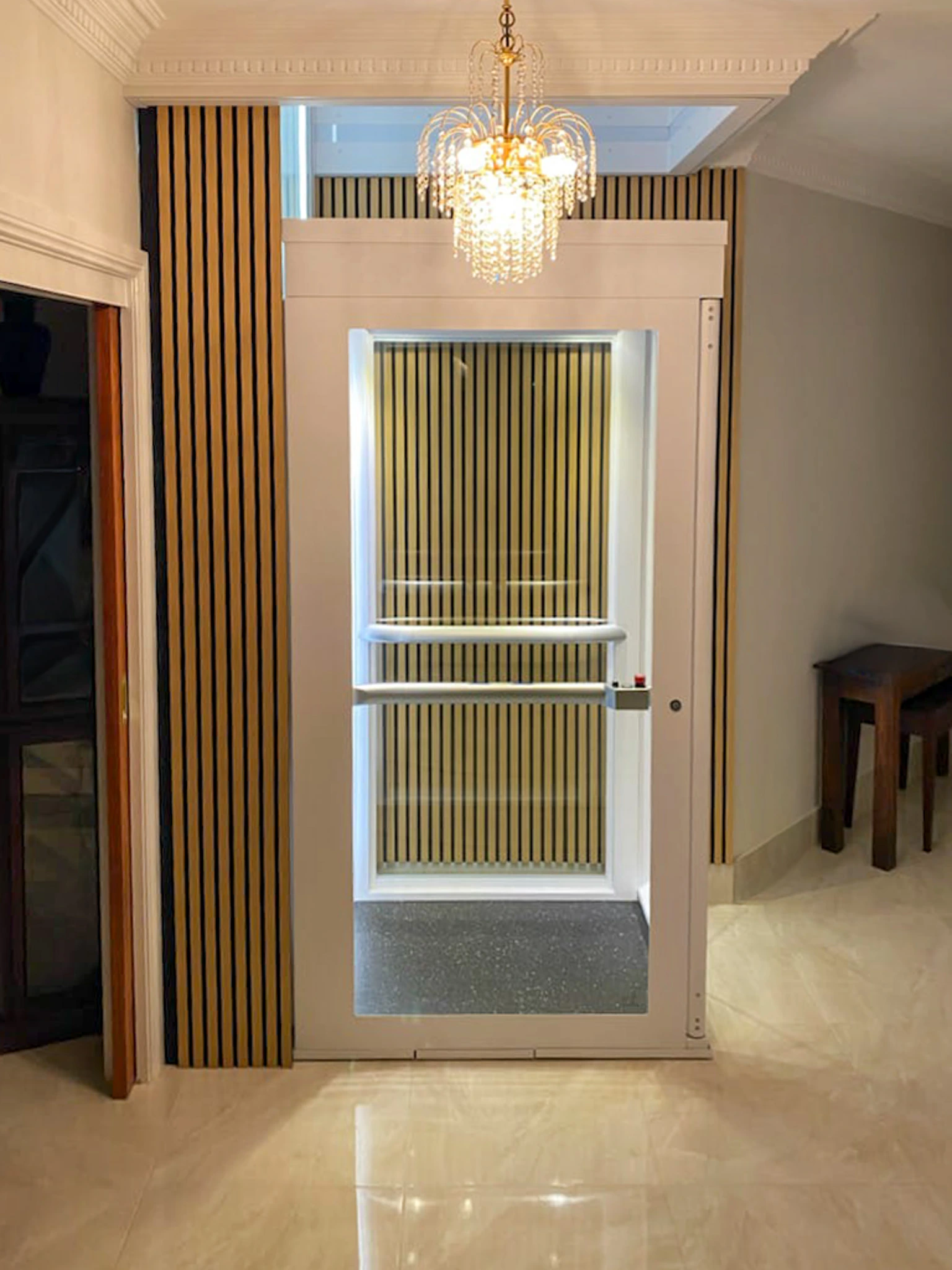 Lift rumah Ascenda 2 lantai dengan shaft putih dan panel kaca pada interior rumah modern cluster BSD