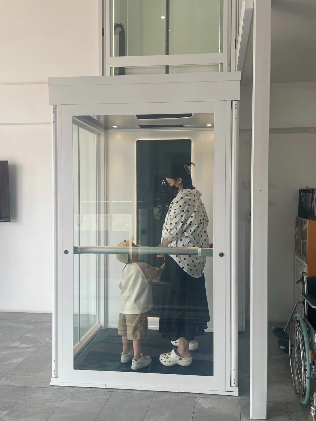 Keluarga menggunakan lift rumah Ascenda dengan akses nyaman untuk anak dan pengguna kursi roda