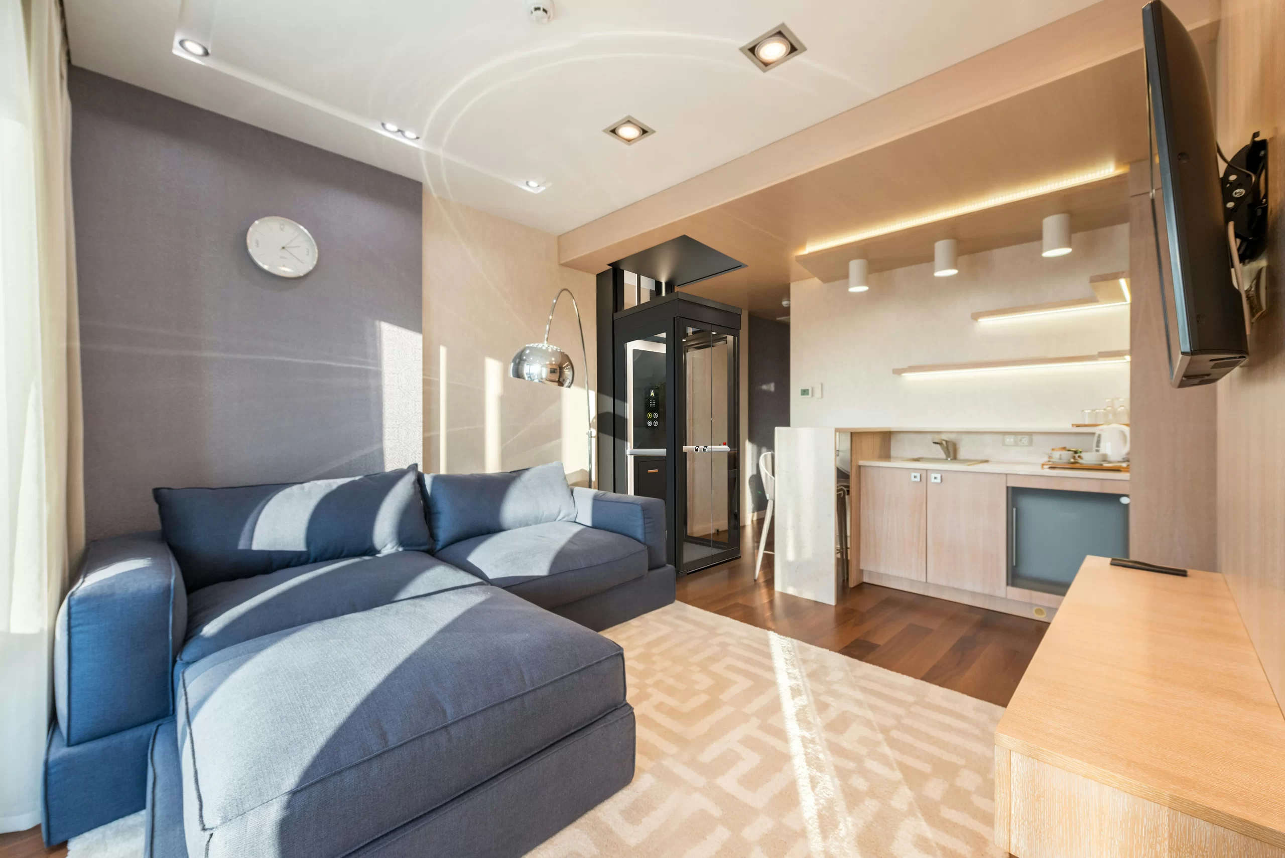 Visual CGI lift rumah Ascenda warna hitam yang terpasang di ruang keluarga modern dengan desain compact dan elegan.