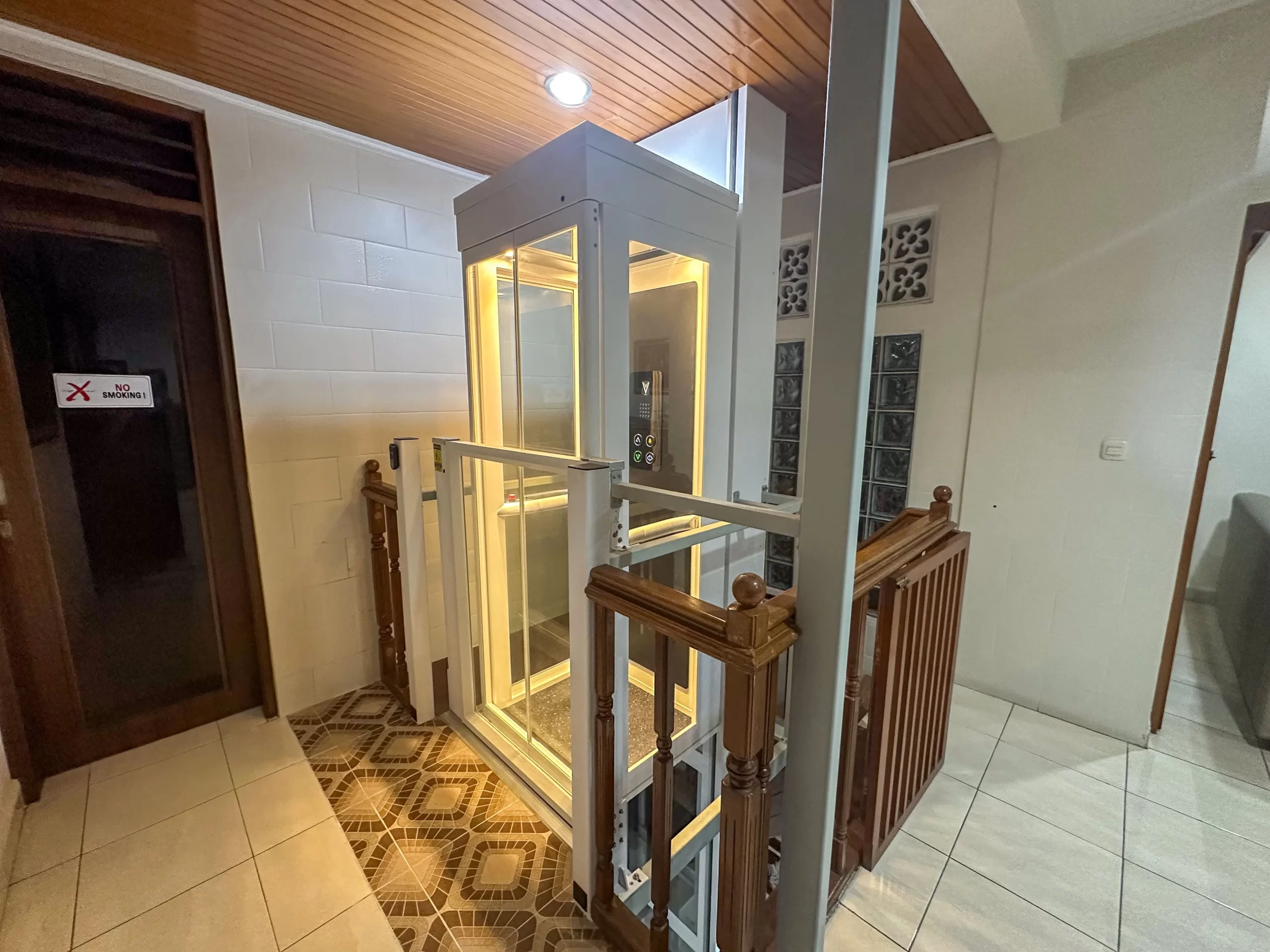 Lift Rumah Terkecil di Indonesia | Ascenda Size S 13 Interior Ascenda Size S dengan control panel, handrail, pencahayaan kabin, dan dinding kaca.